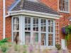 windows on the front of a house with flowers out of focus