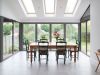 kitchen table surrounded by modern bi-fold doors 