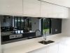 modern kitchen sink and counter with mirrors and splashback