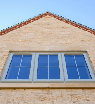 Looking up at three upvc windows on a house