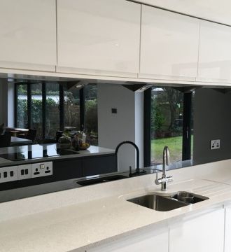 modern kitchen sink and counter with mirrors and splashback