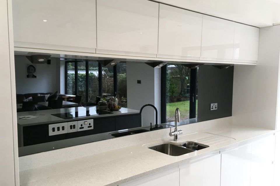 modern kitchen sink and counter with mirrors and splashback