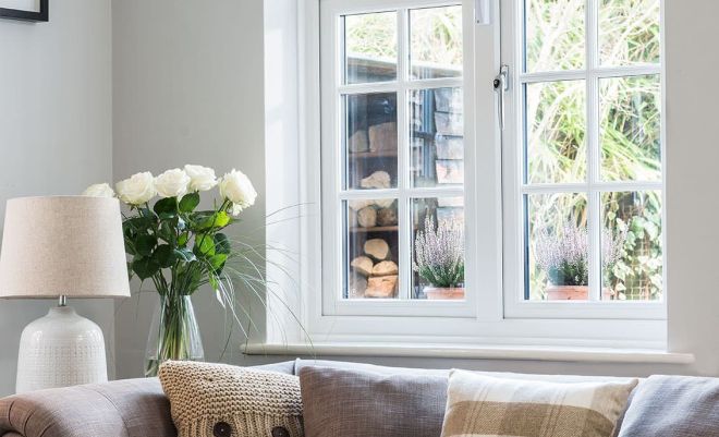 two double glazed windows behind living room sofa