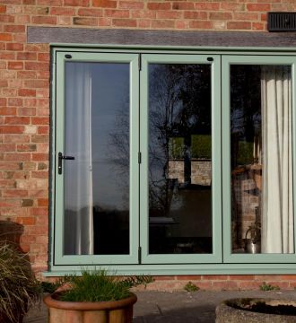 kitchen table surrounded by modern bi-fold doors 