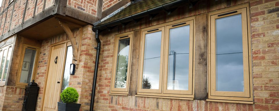 four windows at the front of a house with front door in view