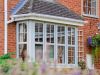 windows on the front of a house with flowers out of focus