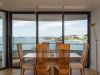 sliding patio doors behind a kitchen table with the ocean in view