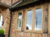 four windows at the front of a house with front door in view