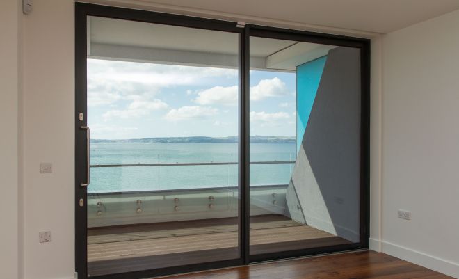 large coastal living room surrounded by patio doors